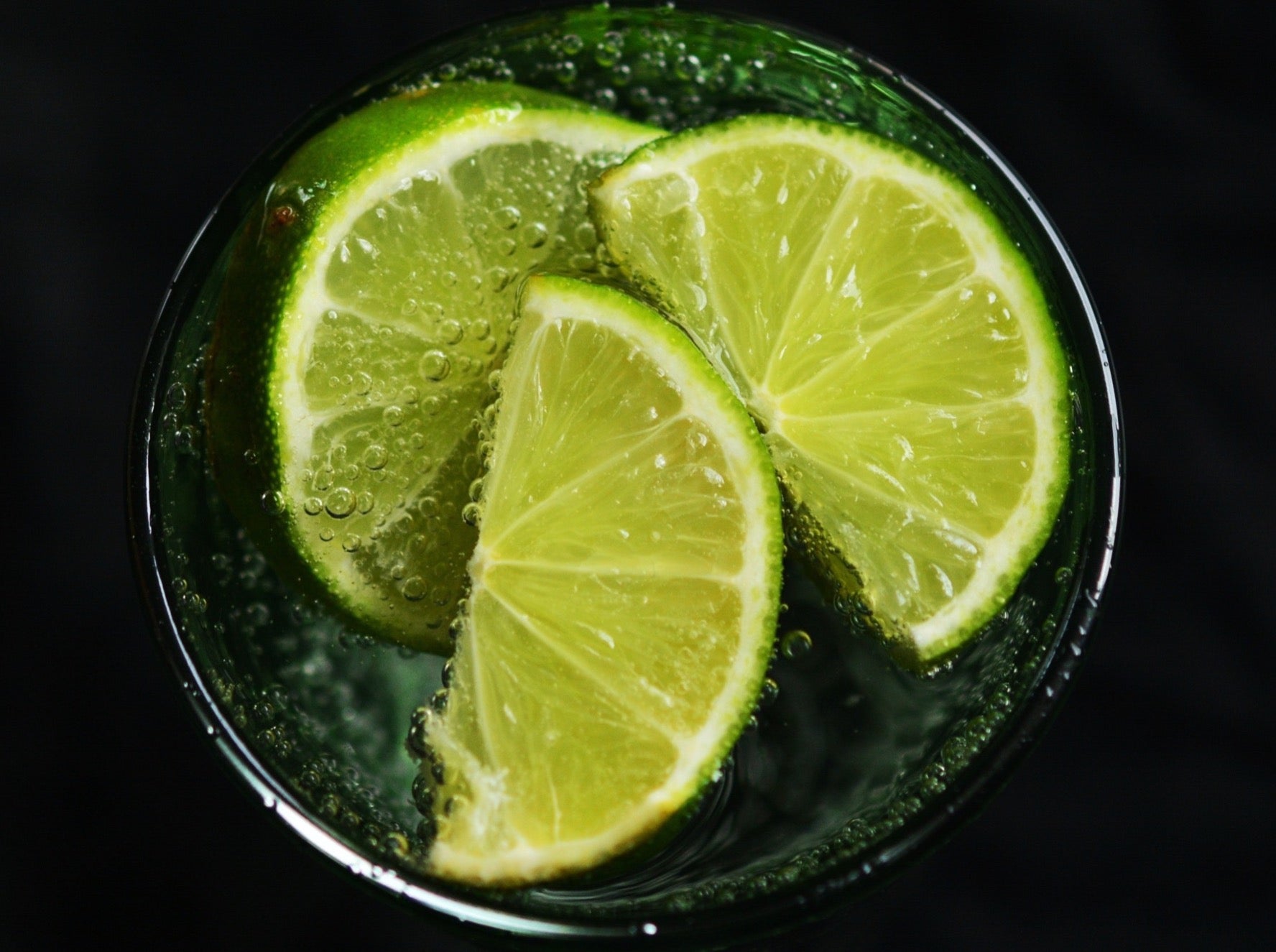 Lime slices floating in a glass of seltzer.